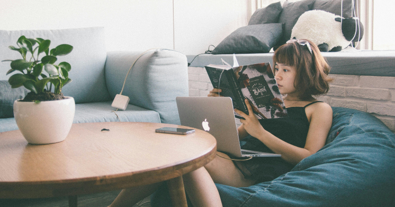 A woman reads comfortably on a stylish Rifezza sofa.